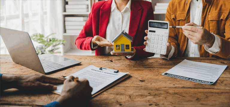 Ehepaar mit Modell eines Hauses und Taschenrechner in einem Büro